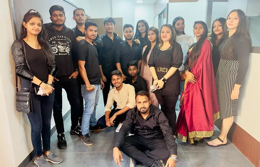 Students dressed in black and traditional attire posing after a celebration