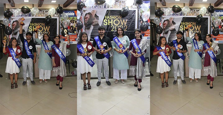 Students posing with sashes and trophies at fashion show